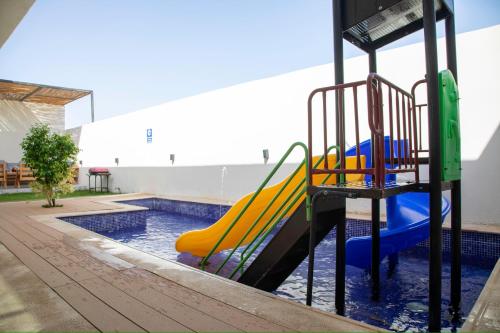 a playground with a slide in a swimming pool at المرفأ 2 شاليه مع مسبح والعاب مائية وغرف نوم فاخرة in Khalij Salman