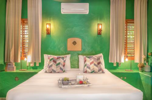 ein Schlafzimmer mit einem großen Bett und einer grünen Wand in der Unterkunft EVALUNA VILLAS LAS TERRENAS in Santa Bárbara de Samaná