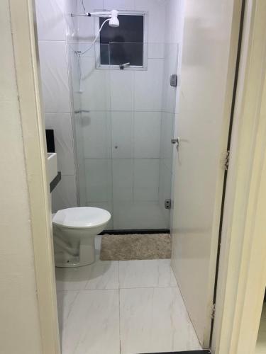 a white bathroom with a toilet and a shower at Praia de jangada 103 - barra de jangada recife in Recife
