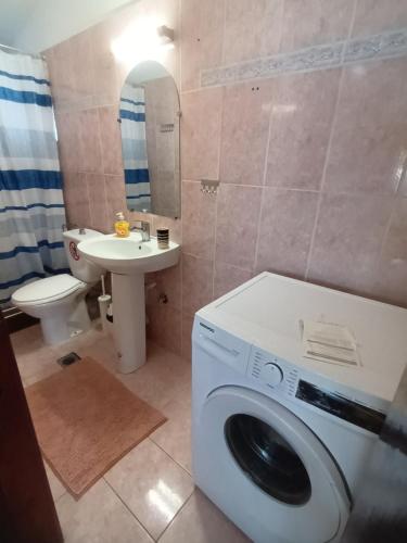 La salle de bains est pourvue d'un lave-linge et d'un lavabo. dans l'établissement Peraia Sea view Apartment, à Néoi Epivátai