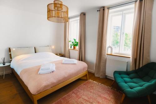 a bedroom with a bed and a green chair at Cosy flat in the heart of Camden in London