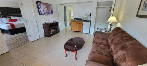 a living room with a couch and a room with a bed at Ramada by Wyndham Mountain Home in Mountain Home