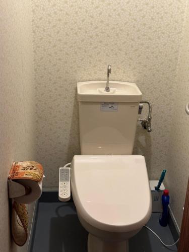 Łazienka z białą toaletą i umywalką w obiekcie 山荘民宿 w mieście Hashiba