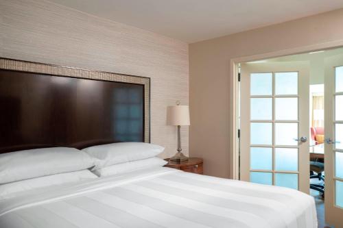 a bedroom with a large white bed and a sliding glass door at Atlanta Marriott Perimeter Center in Atlanta