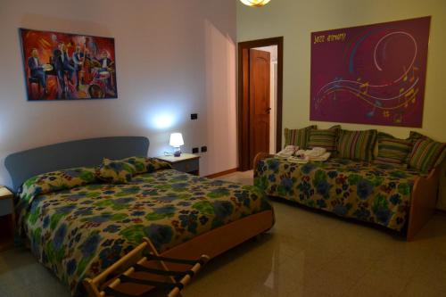 ein Schlafzimmer mit einem Bett und einem Sofa darin in der Unterkunft Art & Music B&B in Villa San Giovanni
