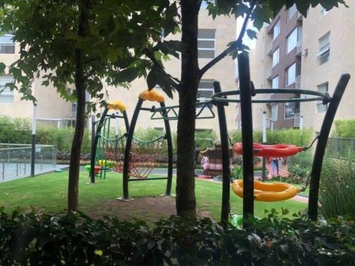 un parque con un parque infantil con toboganes y árboles en Hermoso Departamento al Sur de la Ciudad de Mexico, en Ciudad de México