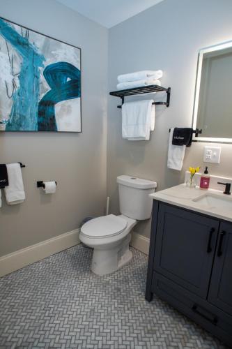 a bathroom with a white toilet and a sink at Gunstock Inn & Suites in Gilford
