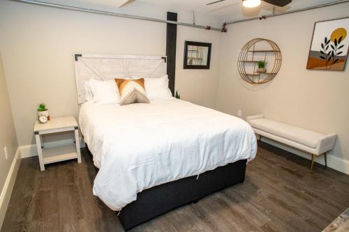 a bedroom with a large white bed and a bench at Gunstock Inn & Suites in Gilford