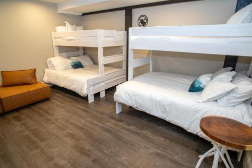 a bedroom with two bunk beds and a table at Gunstock Inn & Suites in Gilford