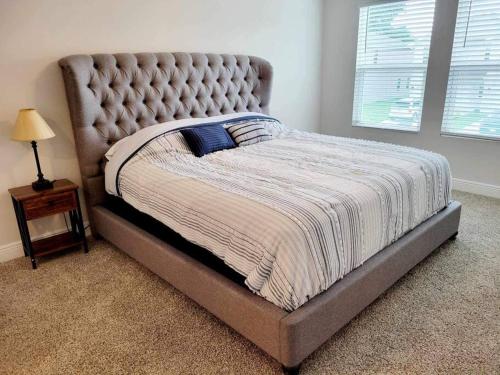 a bed with a tufted bed frame in a bedroom at Brand NEW house in Pensacola EV connector included in Pensacola