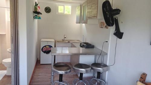 uma pequena cozinha com um balcão e bancos em Cabaña Playera Santa Veronica em Juan de Acosta
