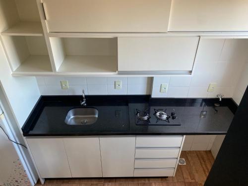 a small kitchen with a sink and white cabinets at Studio Minimalista Região Central Residencial Padre Kolb 201C in Joinville