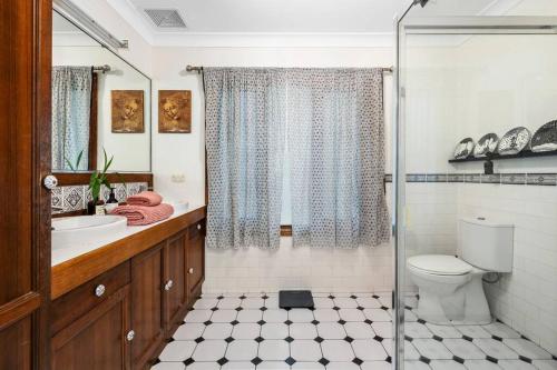 a bathroom with a shower and a toilet and a sink at Buderim Milne House in Buderim