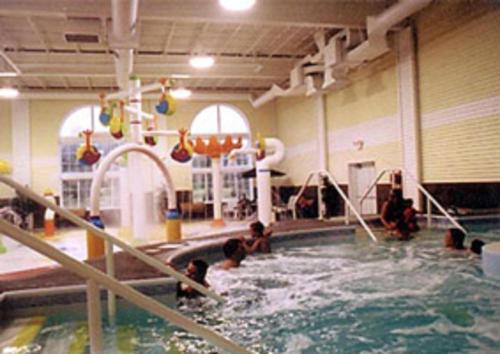 un grupo de niños jugando en una piscina en Great Mackinaw Beachfront Hotel, en Mackinaw City