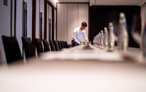 a man standing in front of a long row of chairs at Crowne Plaza Vinh Yen City Centre by IHG in Yen