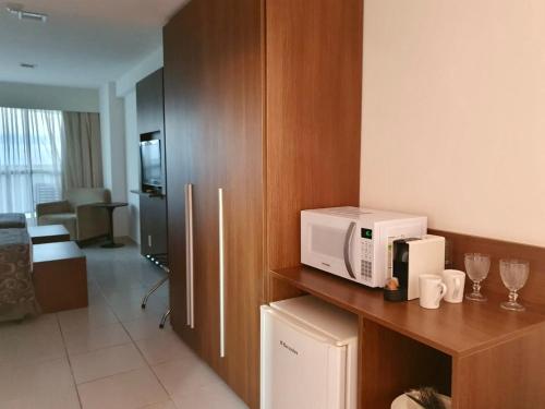 a kitchen with a microwave on top of a counter at Flat Beach Class Internacional in Recife