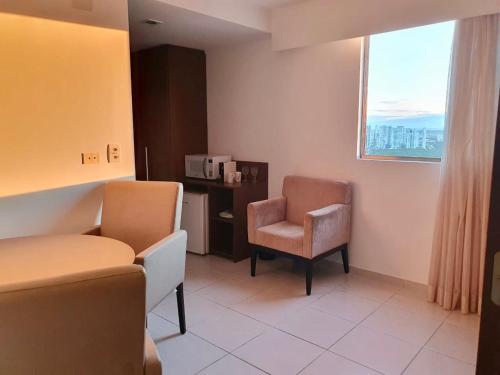 a hospital room with two chairs and a window at Flat Beach Class Internacional in Recife