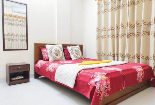 sypialnia z łóżkiem z czerwoną i białą kołdrą w obiekcie Sweet & affordable stay in Dhaka w mieście Dhaka