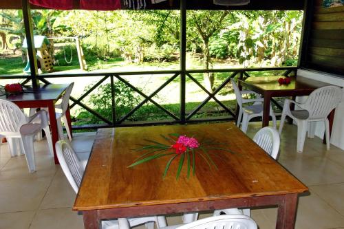 a dining room with tables and chairs and a window at Pension Les Trois Cascades in Uturoa