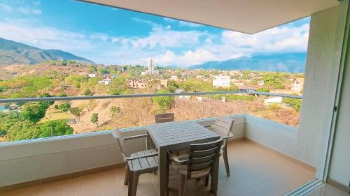 a balcony with a table and chairs and a large window at Santa fe de Antioquia apartamento vacacional di sole 1306 in Santa Fe de Antioquia