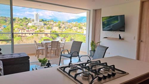 a kitchen with a stove and a living room with a view at Santa fe de Antioquia apartamento vacacional di sole 1306 in Santa Fe de Antioquia