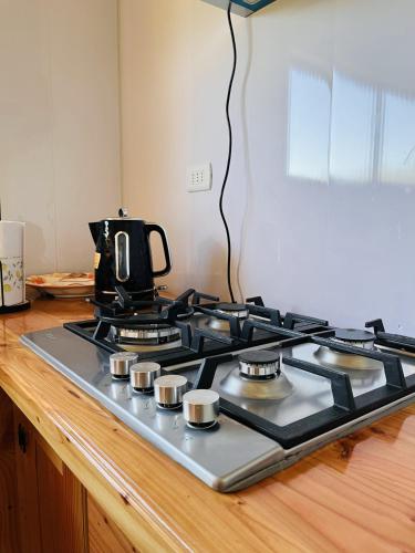 a stove top with a coffee pot on top of it at Mehuín el Remanso de Paz in Mehuín
