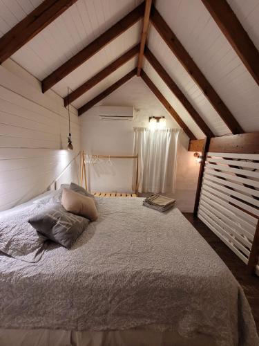 a bedroom with a large bed in a attic at La Cabaña in Puerto Madryn