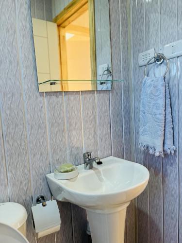 a bathroom with a sink and a mirror and a toilet at Mehuín el Remanso de Paz in Mehuín