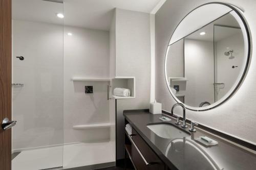 a bathroom with a sink and a mirror and a shower at Courtyard by Marriott St Paul Downtown in Saint Paul