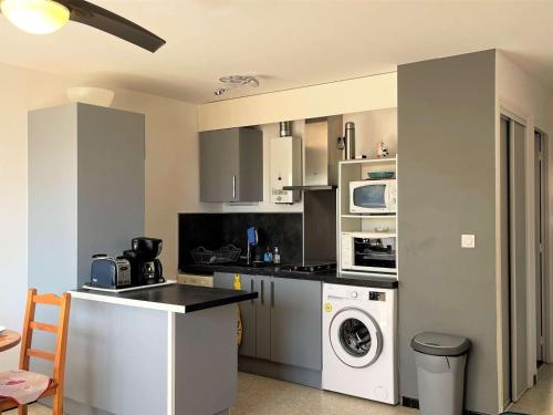 une cuisine avec un lave-linge et un lave-linge dans l'établissement Appartement T2 en Bord de Mer avec Terrasse et Parking à Port-la-Nouvelle, 5 Couchages - FR-1-229C-89, à Port-la-Nouvelle