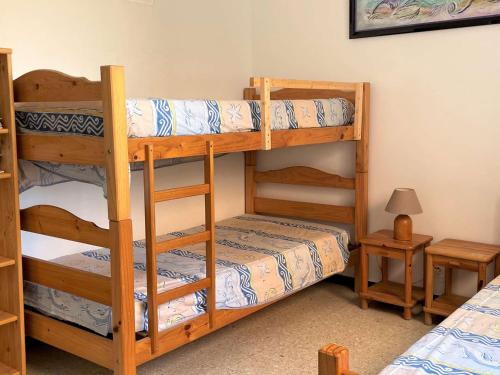 une chambre avec deux lits superposés et une lampe dans l'établissement Appartement T2 en Bord de Mer avec Terrasse et Parking à Port-la-Nouvelle, 5 Couchages - FR-1-229C-89, à Port-la-Nouvelle