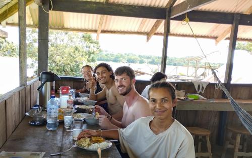 un grupo de hombres sentados en una mesa comiendo comida en Hospedaje y tours Reina Arriera amazonas colombia en Macedonia