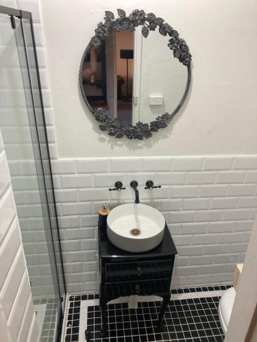 baño con lavabo y espejo en la pared en The Tamarisks at Rosevale, en Bathurst