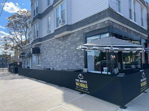 un restaurante con sombrilla frente a un edificio en NY3182-9 Private Office w Double SofaBed Keypad, en Unionport