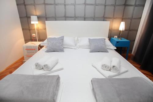 a large white bed with two slippers on it at Happy Dreams Apartment near the beach and old town in Split