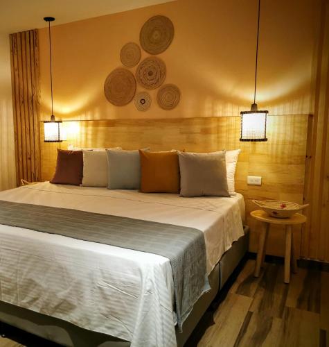 a bedroom with a large bed with two lights at La Martina Boutique Hotel in Medellín