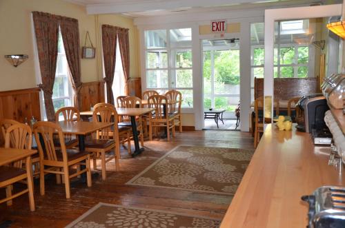 a dining room with tables and chairs and windows at Cornwall Inn in Cornwall Bridge