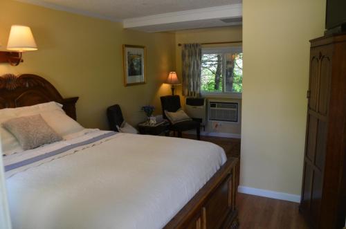 a bedroom with a bed and a room with a chair at Cornwall Inn in Cornwall Bridge
