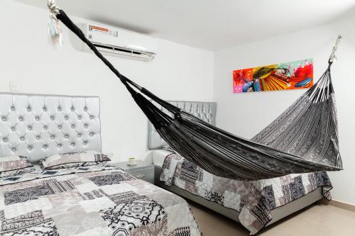 een hangmat boven een bed in een slaapkamer bij Hotel Galanni in Valledupar