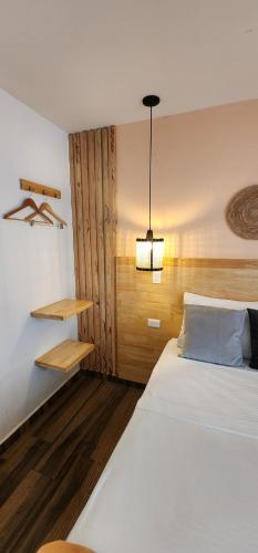 a bedroom with a large white bed and a light at La Martina Boutique Hotel in Medellín