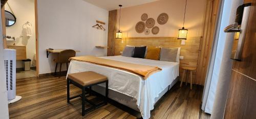 a bedroom with a bed and a chair in it at La Martina Boutique Hotel in Medellín
