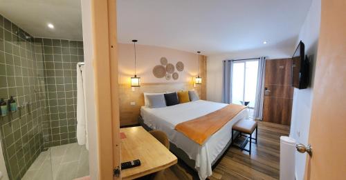 a hotel room with a bed and a shower at La Martina Boutique Hotel in Medellín