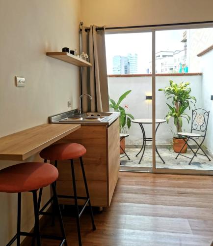 a kitchen with a sink and a counter with stools at La Martina Boutique Hotel in Medellín