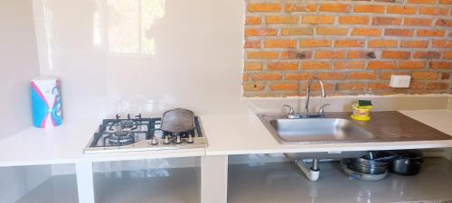 a kitchen counter with a sink and a stove at La ROBLEDA CASA DE CAMPO in Zapopan