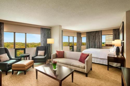 a hotel room with a bed and a living room at The Westin Southfield Detroit in Southfield