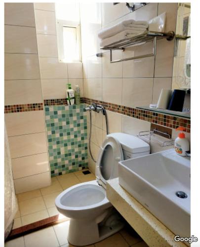 a bathroom with a toilet and a sink at Baby Family in Jinning