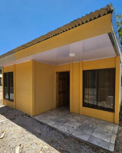 uma pequena casa amarela com um grande pátio em Inf casa vacacional 