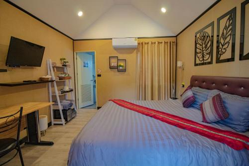 a bedroom with a bed and a desk and a television at ฟินอินดอย in Chom Thong