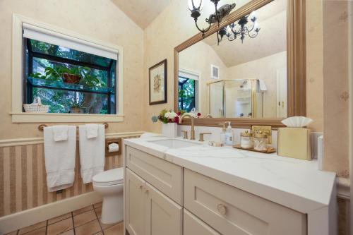 a bathroom with a sink and a toilet and a window at Mill Rose Inn in Half Moon Bay