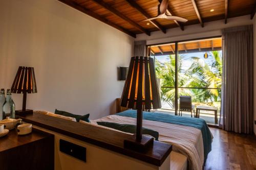 a bedroom with a bed with a desk and a window at BK Beach Boutique Hotel - Hikkaduwa in Hikkaduwa